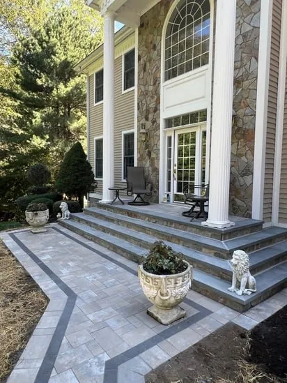The finished Milford CT pavers project with decorative lion statues and new landscaping mulch.