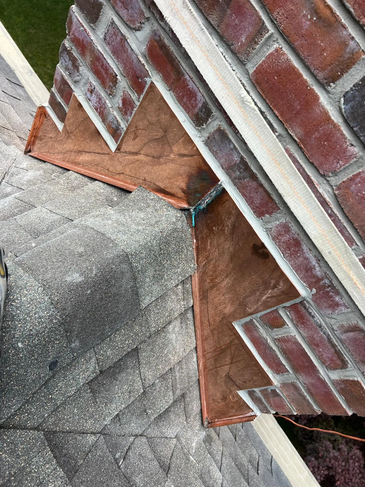 Close-up of the professional copper flashing installed during a chimney repoint in Milford, CT, ensuring a leak-proof roof seal.